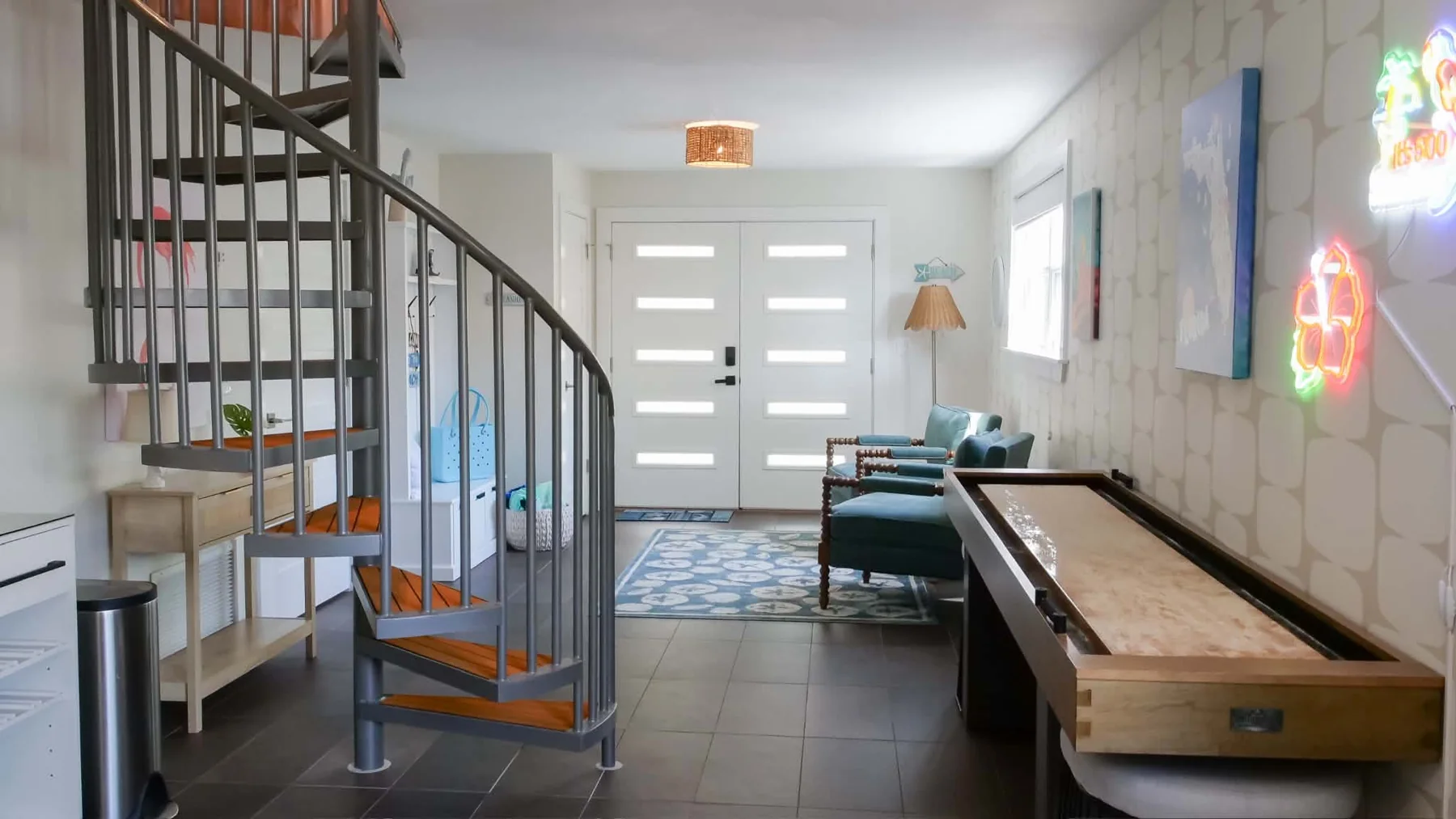 Games room with shuffleboard table and spiral staircase