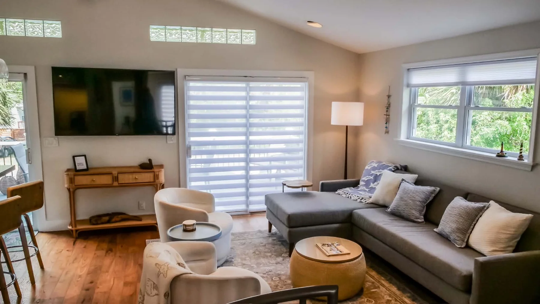 Bright living room with a sofa, coastal decor and shuttered windows