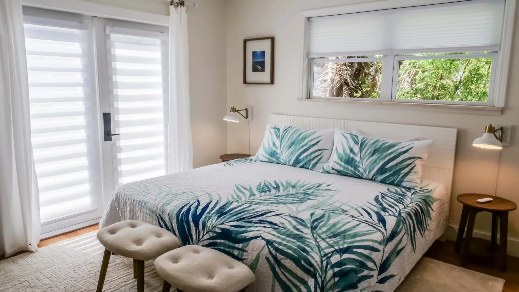 Bedroom with palm-patterned bedding and white shutters
